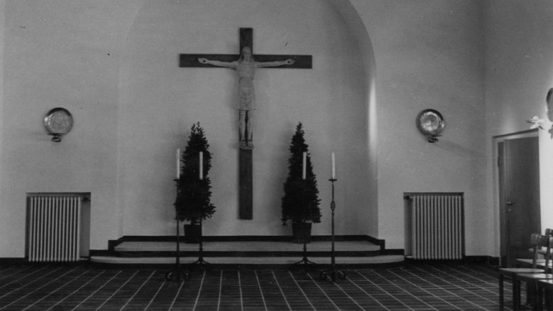 Die Stirnseite der Leichenhalle mit Aufbahrungsstätte und Kreuz im Jahr 1950 Die Stirnseite der Leichenhalle mit Aufbahrungsstätte und Kreuz im Jahr 1950
