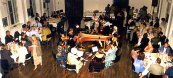 Das Foto zeigt die Musiker in der Mitte, drumherum die gedeckten Tische mit Zuhörern
