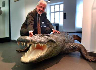 Das Bild zeigt Bürgermeister Huhn mit dem Krokodil im Stadtmuseum