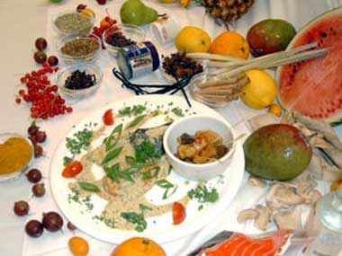 Das Bild zeigt auf einem Tisch angerichtete Gewürze und Obstsorten.