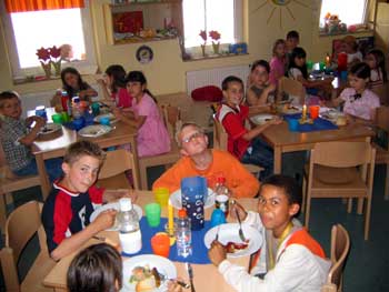Kinder der offenen Ganztagsschule sitzen beim Mittagessen zusammen am Tisch.