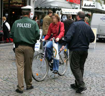 Polzei und Ordnungsamt bei der Kontrolle einer Radfahrerin in der Fußgängerzone