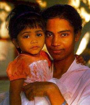 Eine indische Frau mit ihrer kleinen Tochter auf dem Arm