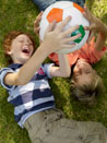 Das Bild zeigt zwei Kinder mit einem Fußball