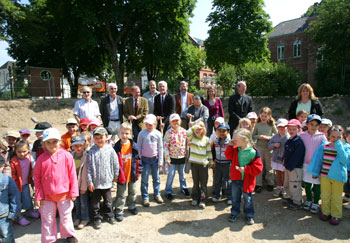 Das Bild zeigt die Kinder des  Kindergartens Wolsdorf und Bürgermeister Huhn beim Spatenstich