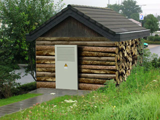 Das Bild zeigt eine Trafostation, die wie ein Holzhaus aussieht