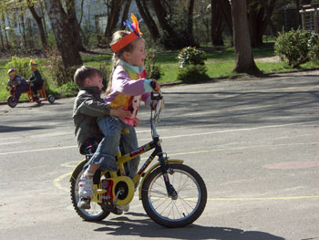 Das Bild zeigt zwei Kinder auf einem Fahrrad
