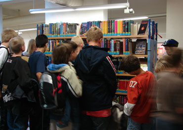 Das Bild zeigt viele Jugendliche in der Bibliothek