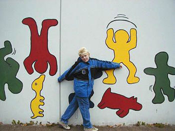Das Bild zeigt einen Schüler vor der neugestalteten Schulhofmauer