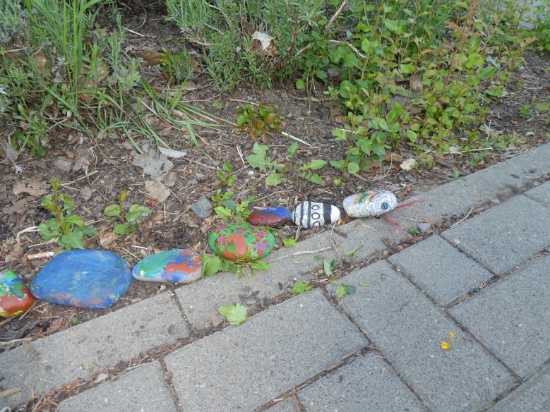 2020-05-10_Kita Purzelbaum Bunt bemalte Steine am Rand eines gepflasterten Wegs