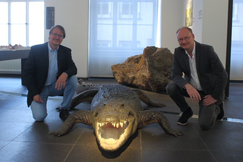 2020-05-15_Stadtmuseum Zwei Männer knien neben einem ausgestopften Krokodil