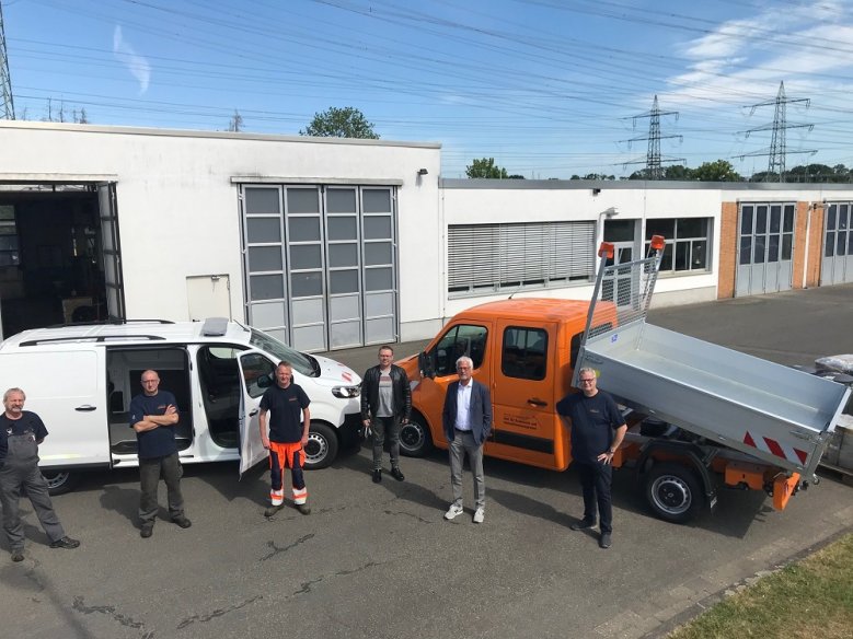 2020-05-27_Fahrzeuge-Bauhof Sechs Männer stehen vor zwei Autos, einem weißen Kastenwagen und einem gelben Kleinlaster mit Kippladefläche