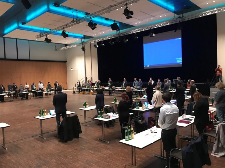 2020-11-25_rat-rhein-sieg-halle Stehende Abgeordnete bei der Ratssitzung in der Rhein-Sieg-Halle
