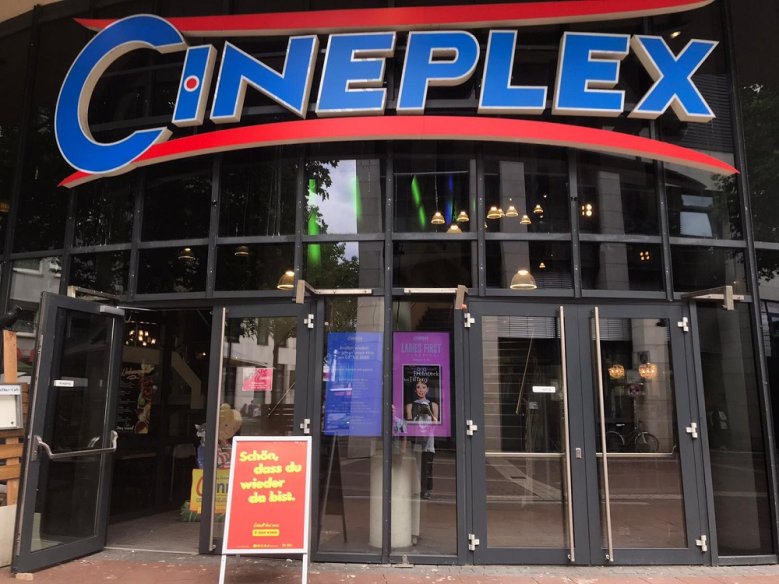 2020-07-01 Cineplex Eingangsbereich des Kinocenters "Cineplex" mit einer geöffneten Tür und einem Aufsteller mit dem Schriftzug "Schön, dass du wieder da bist"