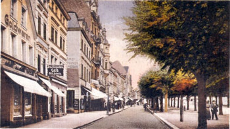 Markt 1915 Der Markt im Jahre 1915: Hinter Bäckerei und Café Wilhelm Schmitz kommen Schreibwaren Franken und Lederwaren Nettekoven, dann die beiden Herrenmodengeschäfte Voß und Wagner