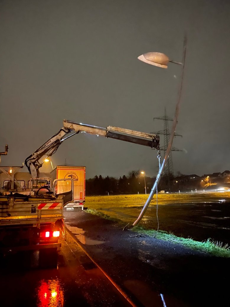 Unfall Isaak-Bürger-Straße Umgefahrene Straßenlaterne, die von einem Kranwagen gehalten wird