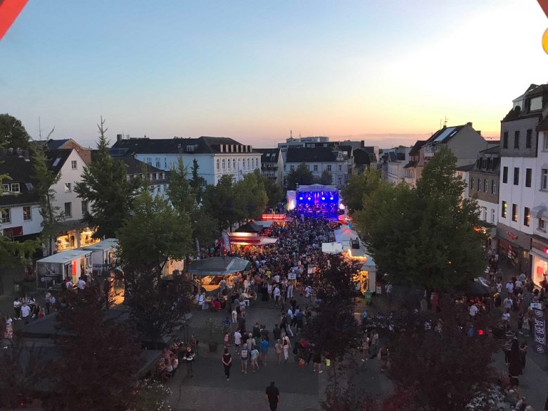 2020-05-14_Stadtfest-C Alexandra Weyel Luftbild von Menschen vor einer ausgeleuchteten Bühne auf dem Siegburger Markt, im Hintergrund Abendhimmel