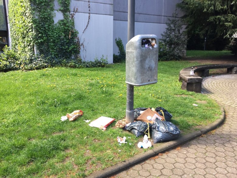 Müll Neben einem vollen Abfallbehälter abgestellter Partymüll