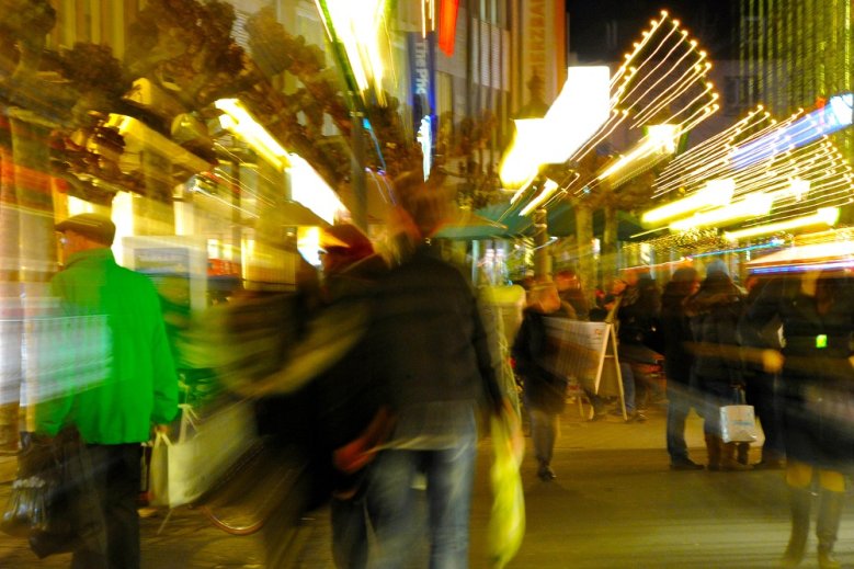 Einkaufsstadt Siegburger Fußgängerzone mit verschwommenen Passanten und Lichtern