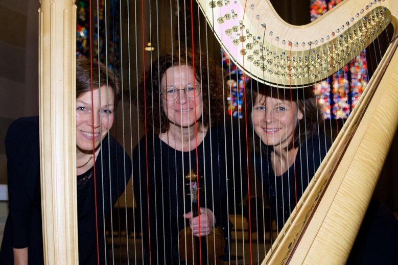 Frauen hinter Gittern Karen Fälker-Herkenhöhner, Bettina Hanschel- Lüdemann und Agnieszka Gralak hinter den Saiten einer Harfe