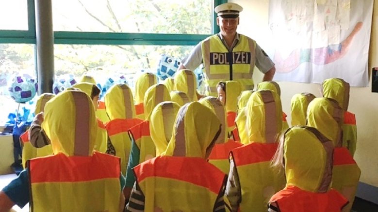 Warnwesten Polizist und Schüler in Warnwesten gekleidet.