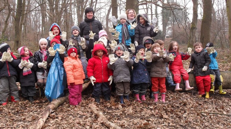 Stadtputztag Viele Kinder die Handschuhen und Mülltüten in der Hand haben