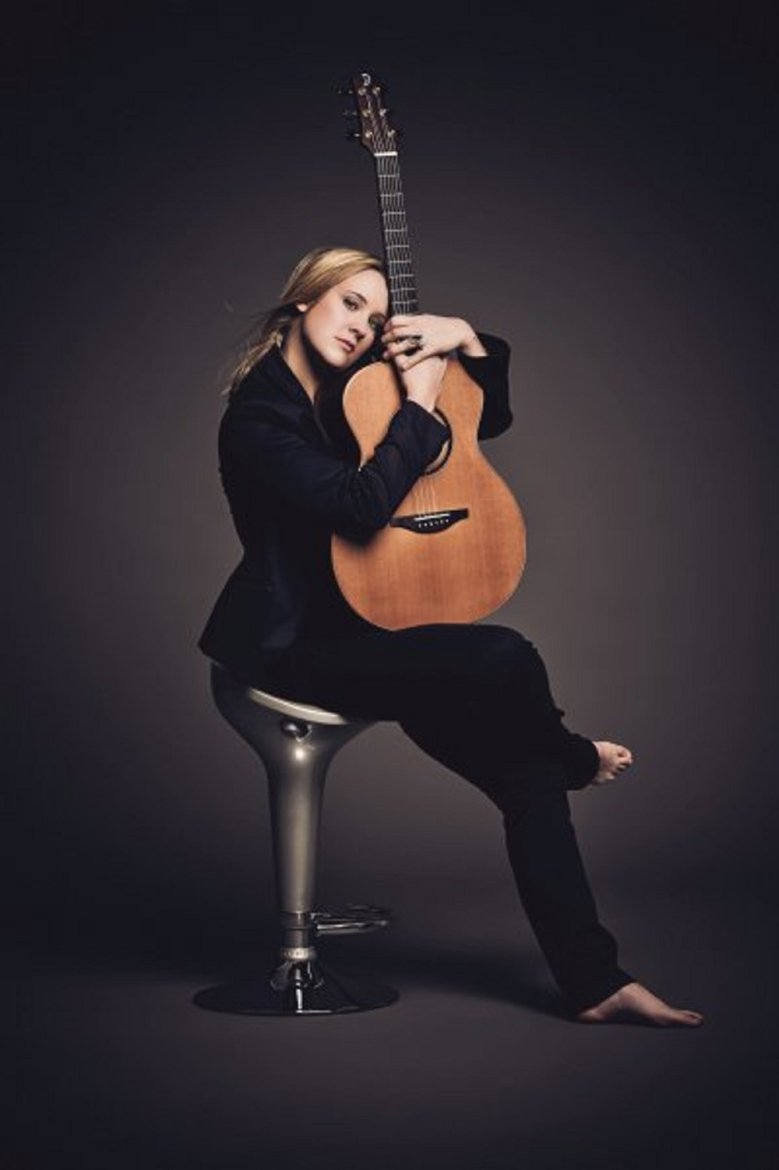 Jule Maklischke-Jan Waldorf sitz auf einem Stuhl mit einer Gitarre im Arm