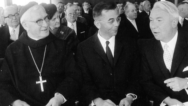 Alkuin (Heising) hieß der 48. Siegburger Abt. Hier (Mitte) im schwarzen Anzug bei der feierlichen Einweihung des Siegburger Rathauses am 10. August 1968 im Sitzungssaal. Altabt Dr. Schulte Strathaus (links) kam im gewohnten Ornat, rechts der stets gestrenge und scharfscheitelige Oberkreisdirektor Paul Kieras. Alkuin legte noch im selben Jahr sein Amt nieder, begründete dies mit dem autoritären Stil der Amtskirche. Alkuin