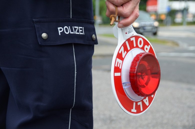 Verkehrskontrolle Polizeikelle in der Hand eines Polizisten.