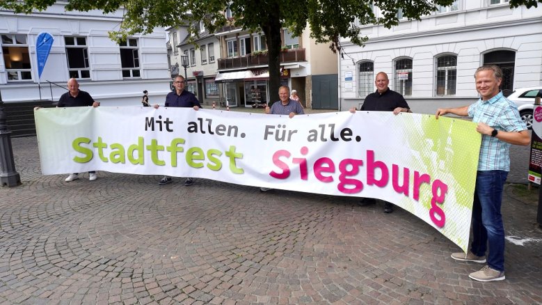 Stadtfest PK Bernd Lehmann, Stefan Rosemann, Markus Steffens, Andreas Burgemeister und Johannes Wingenfeld mit dem Banner "Mit allen. Für alle. Stadtfest Siegburg"