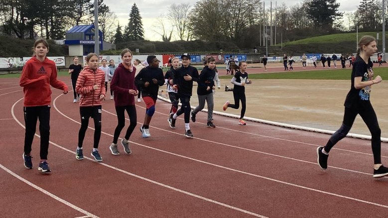 Sponsorenlauf Gymnasium Alleestraße Auf einer Tartanbahn laufende Schülerinnen.