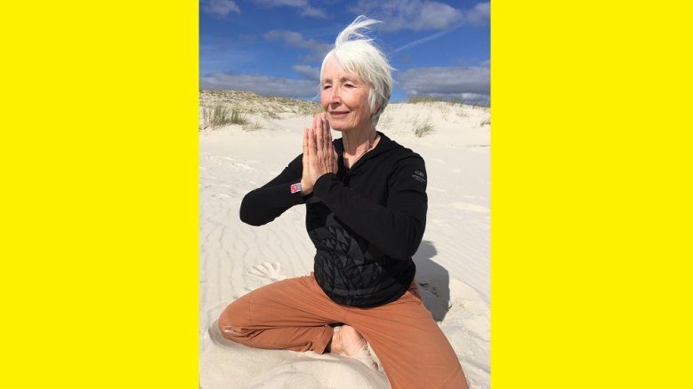 Yoga Yoga betreibende Frau am Strand.