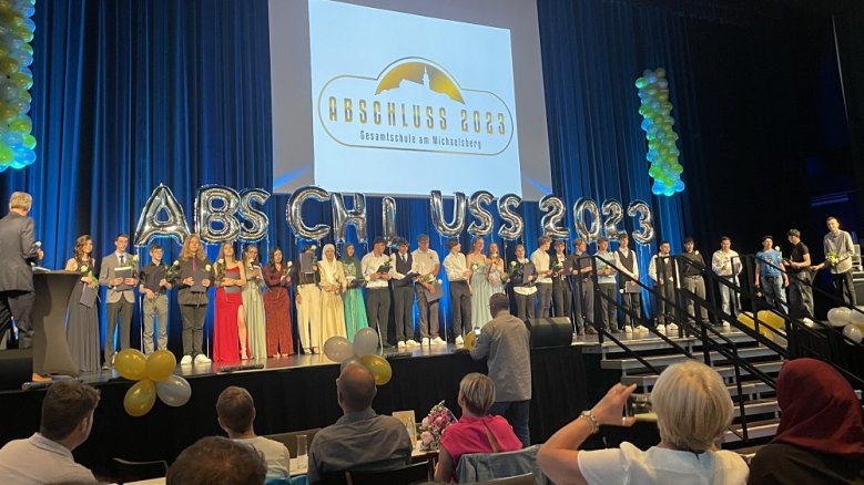 Gesamtschule 10er-Abschluss Gesamtschüler vor dem Schriftzug "Abschluss 2023" auf der Bühne im Rhein Sieg Forum.