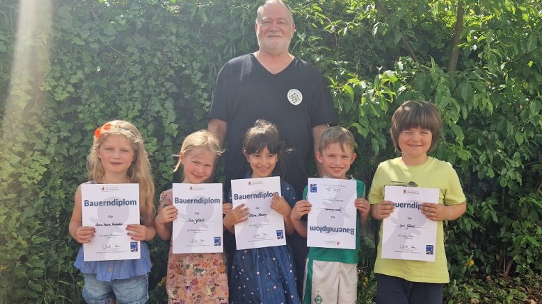 Murkel Schachdiplom Herbert Benesch und fünf Kinder der Kita Murkel II mit ihren Bauerndiplomen.