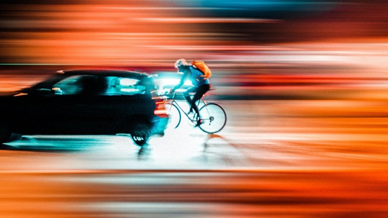 Mobilität Auto und Radfahrer vor Lichtstreifen