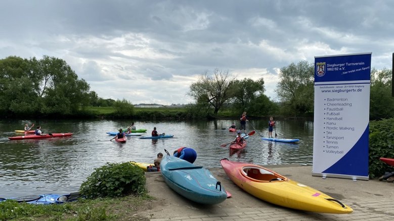 Schnupperpaddeln STV Boote an Land und im Wasser.