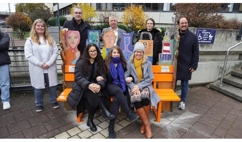 Die Hennefer Schülerinnen Denzia (h.l.), Manal (v.l.) und Julie (2.v.r.) mit Bürgermeister Stefan Rosemann, Ulrich Feyerabend, Direktor des Amtsgerichts, Marco Herrlich, Geschäftsführer des Evangelischen Jugendwerks, hinten, sowie vorne Eva Zoske und Christiane Pipke, Gleichstellungsbeauftragte der Stadt Siegburg, an der orangen Bank. 