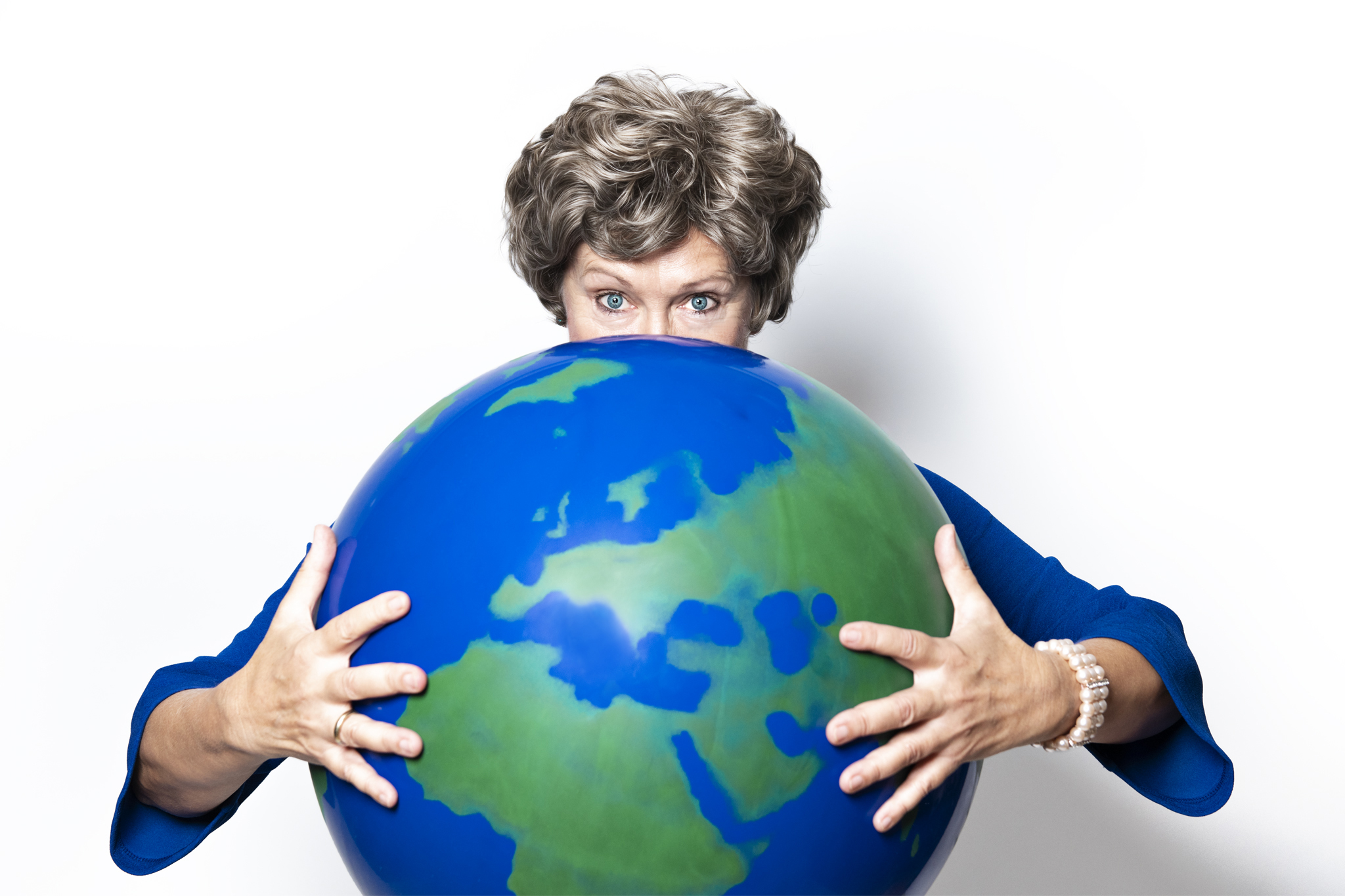 Ein Foto der Künstlerin Lioba Albus mit einem Globus in den Händen, hinter dem sie den unteren Teil ihres Gesichts versteckt.