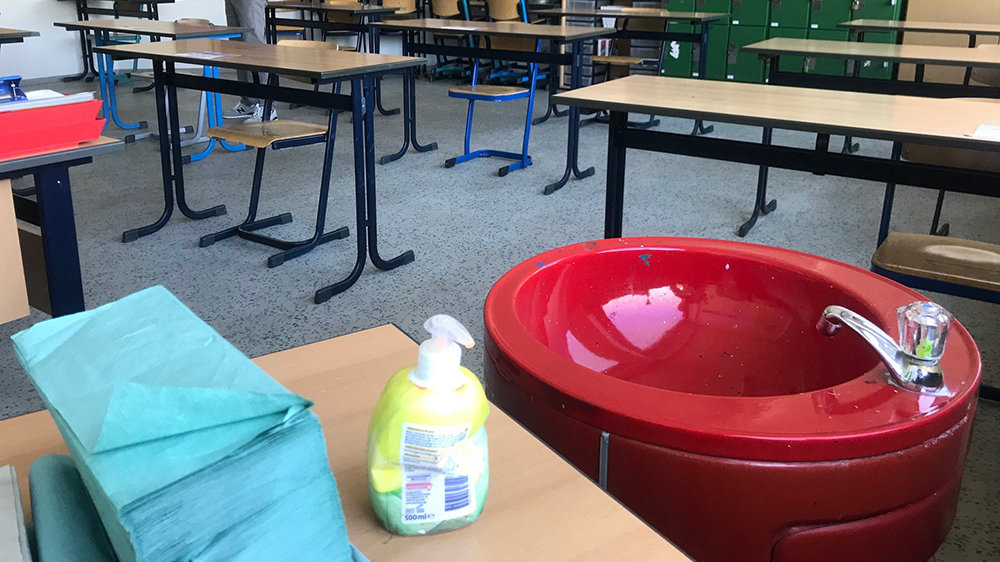 Klassenraum im Schulzentrum, vorne rotes Waschbecken