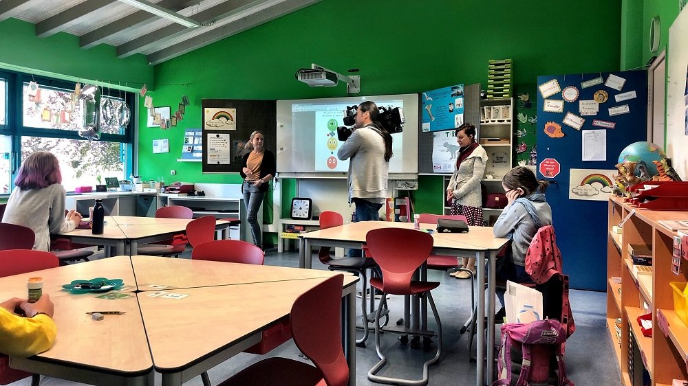 Filmteam in einem Klassenraum mit wenigen Kindern 