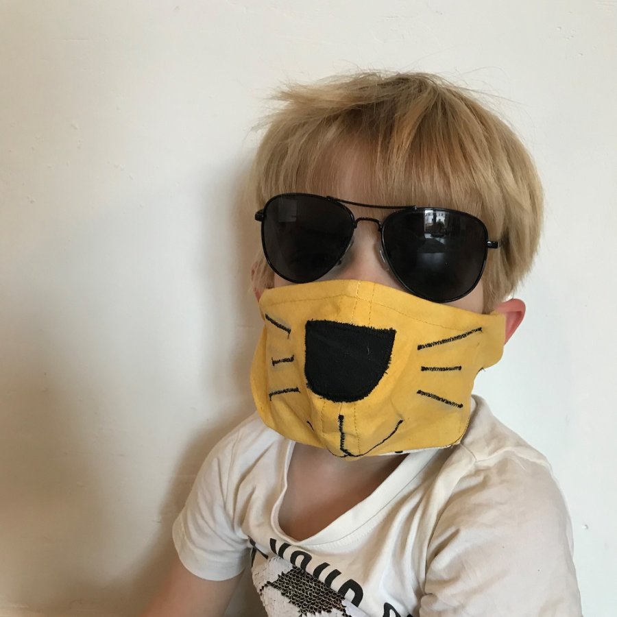 Kind mit Sonnenbrille und Löwen-Maske
