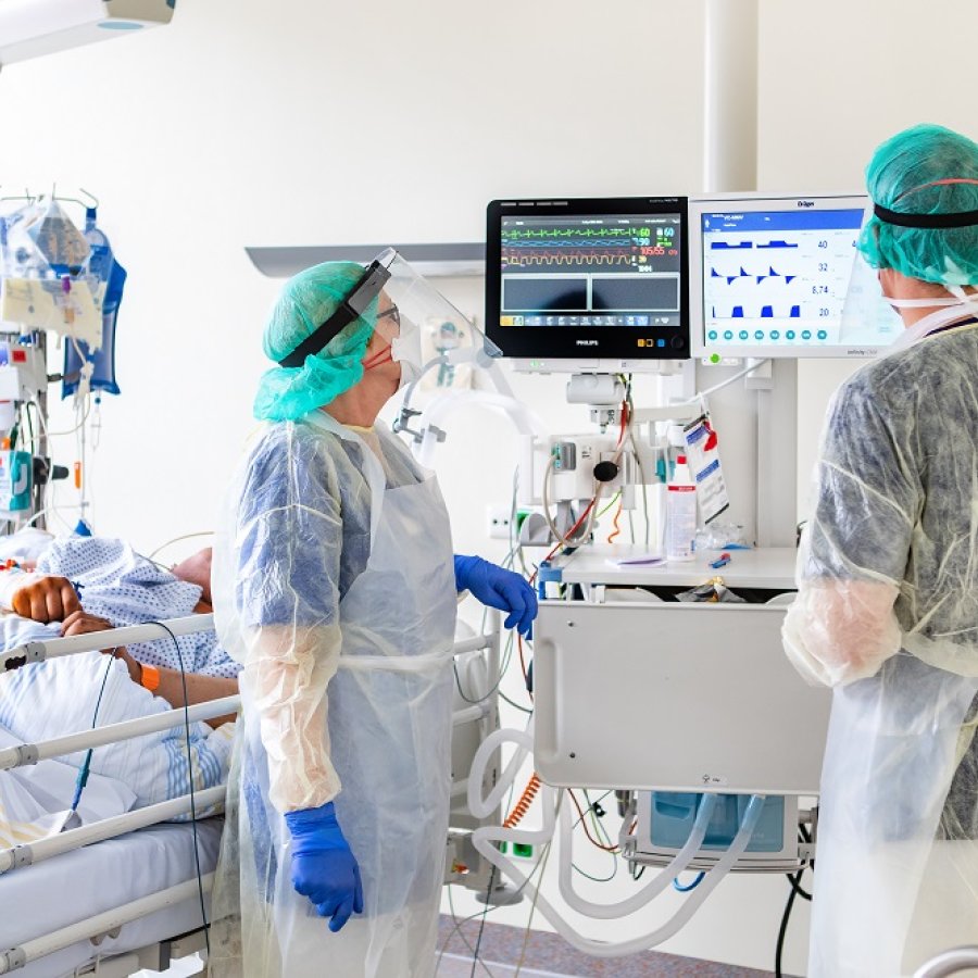 Ärzte überwachen die Maschinen am Bett eines künstlich beatmeten Patient.