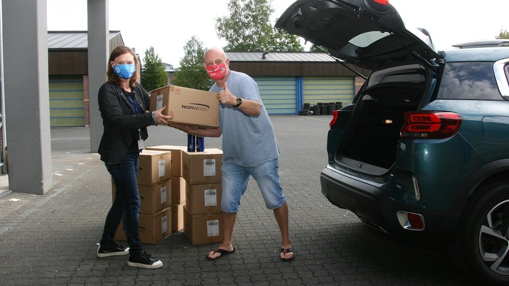 Zwei Personen packen Kartons in ein Auto