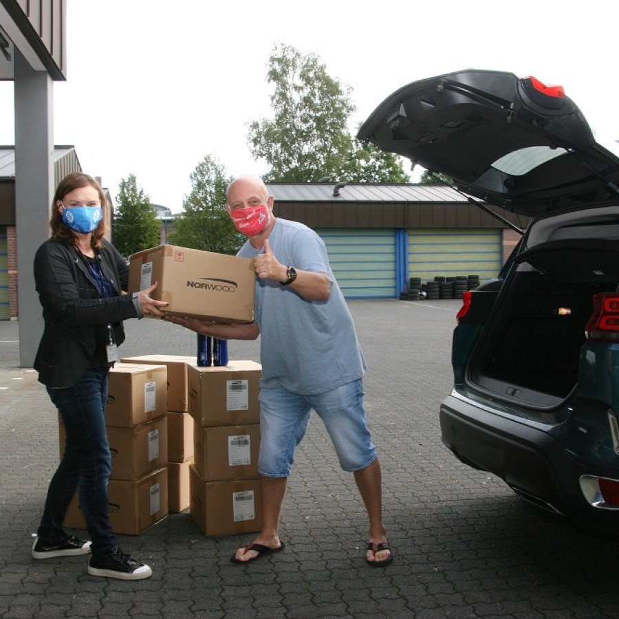 Zwei Personen packen Kartons in ein Auto