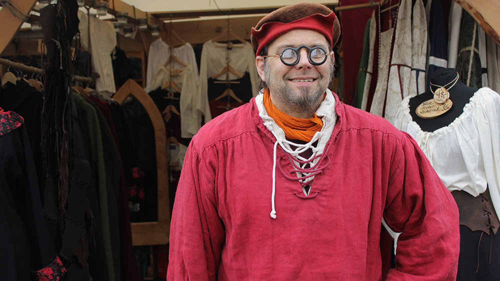 Gewandschneider Jens Genning in seinem Marktstand auf dem Mittelalterlichen Markt
