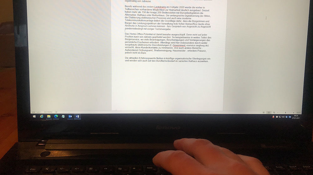Bildschirm mit Text und eine Hand auf der Tastatur