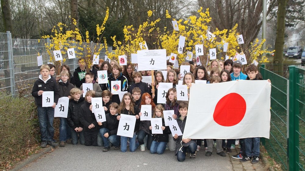 Schüler mit Japanflagge und japanischem Schriftzeichen