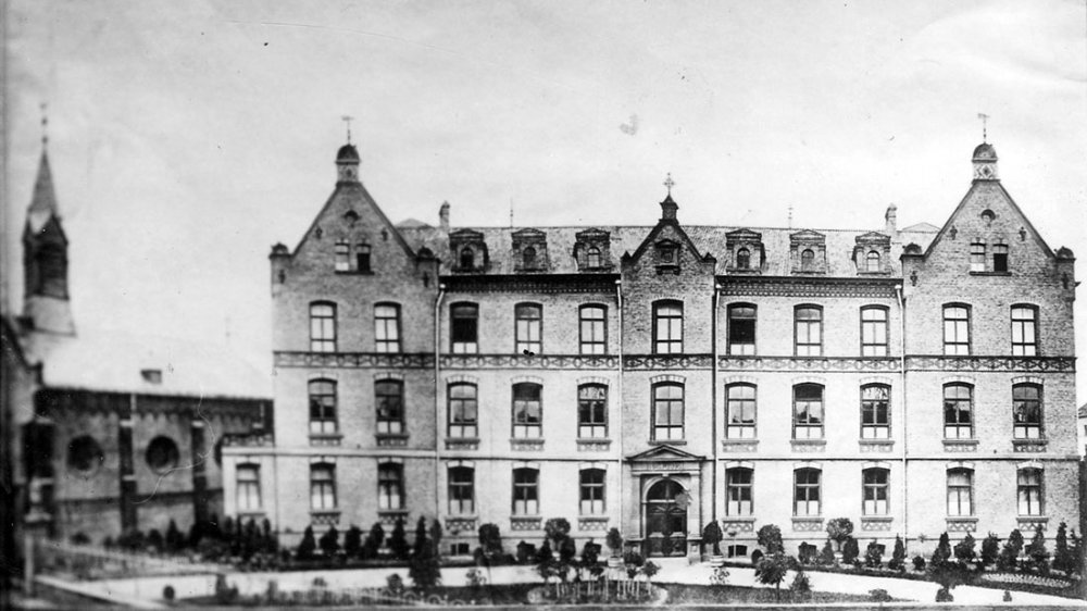 Das 1966 gesprengte Krankenhaus von 1880/81, links die Kapelle an der Ringstraße/Ecke Humperdinckstraße, rechts geht es zur Kaiserstraße