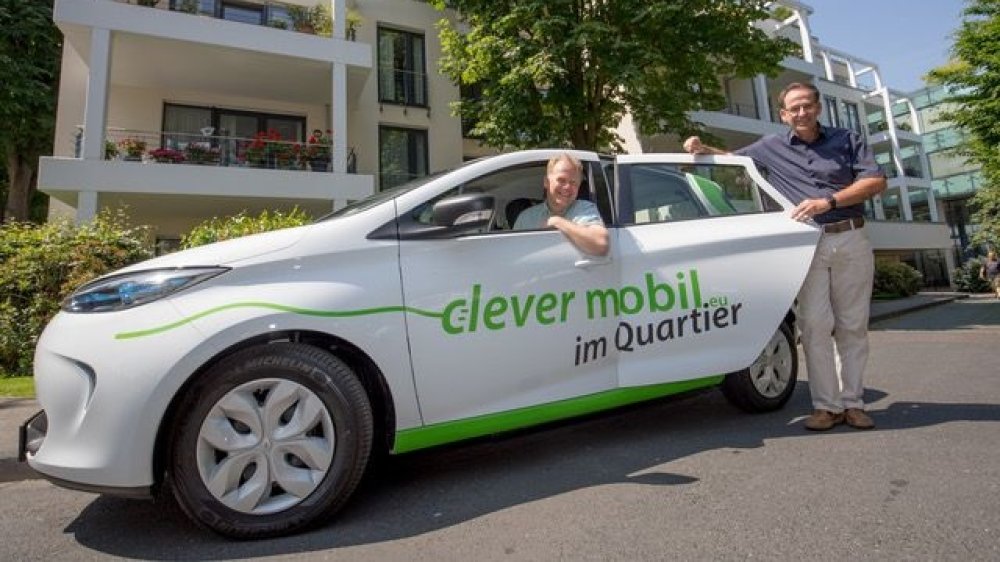 Thomas Zwingmann im und Thomas Schmitz an einem E-Auto