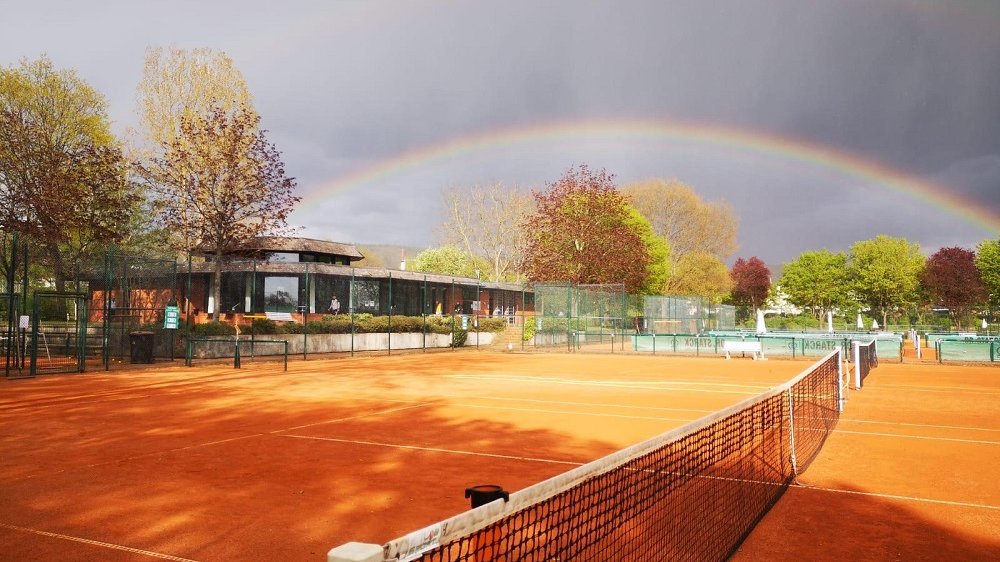 Doppelte Regenbogen über einem Tennisplatz.